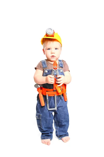 Маленький хлопчик в помаранчевому шоломі з інструментами на білому тлі Ліцензійні Стокові Фото