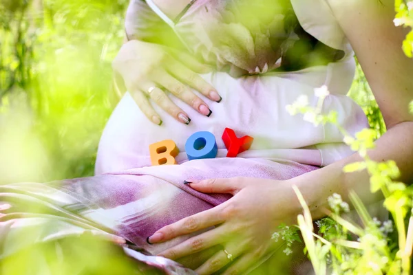 Palavra menino escrito com cubos alfabeto colorido na barriga grávida — Fotografia de Stock