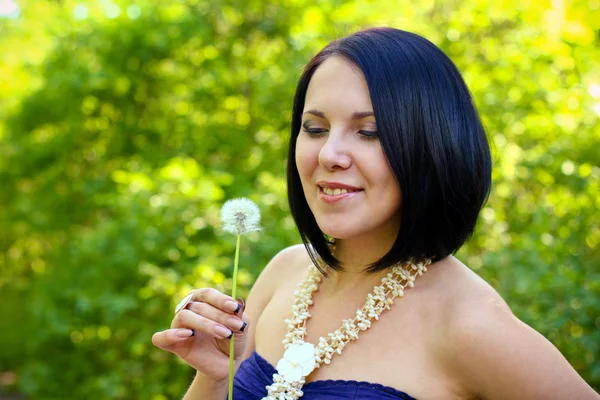 Jovem mulher atraente com dente de leão no parque de verão — Fotografia de Stock