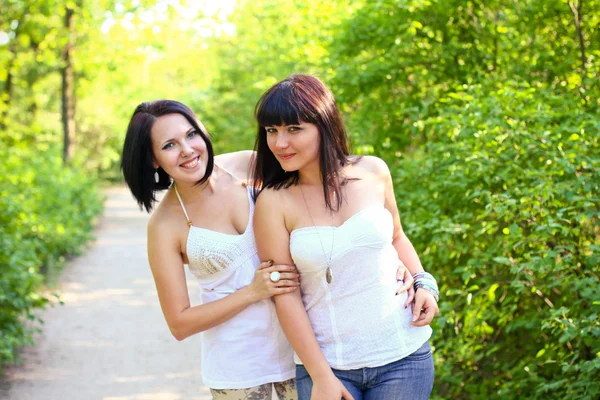 Duas mulheres morenas felizes em um parque de verão Imagens De Bancos De Imagens Sem Royalties