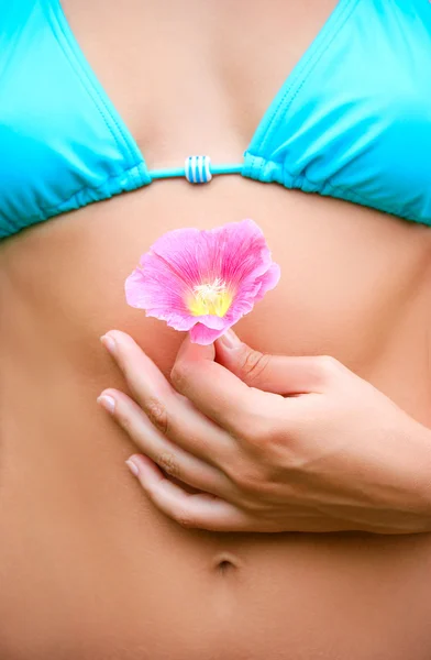 Pancia femminile e fiore primo piano — Foto Stock