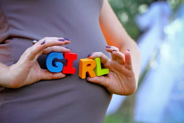 Έγκυος γυναίκα που κρατά το κορίτσι λέξη — Φωτογραφία Αρχείου