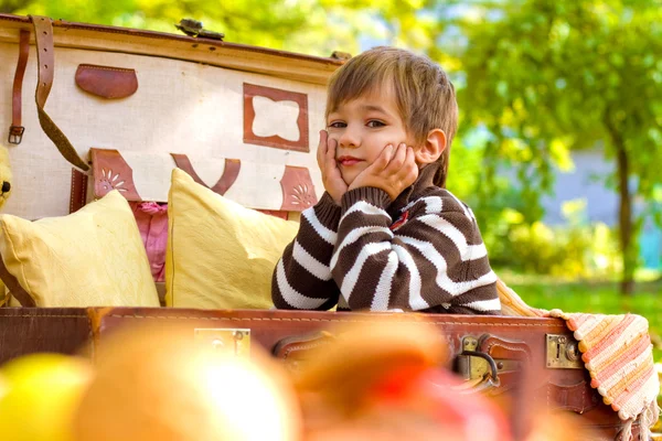 Kleiner Junge sitzt im alten Koffer — Stockfoto