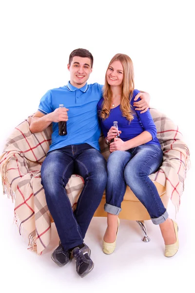 Young people sitting on a sofa and drinking Coca Cola — Stock Photo, Image