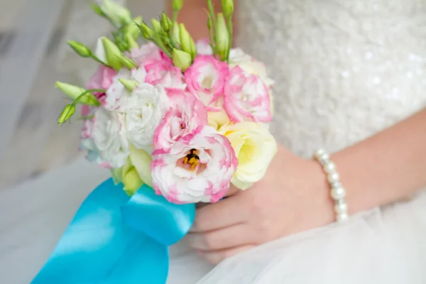 Невеста держит свадебный букет близко — стоковое фото
