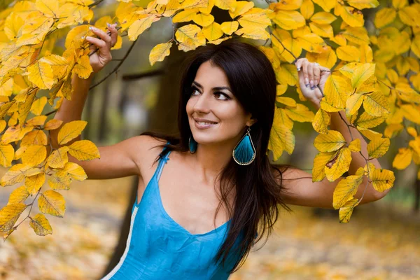 Kvinna med gula blad på hösten — Stockfoto