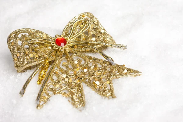 Golden bow on white snow — Stock Photo, Image