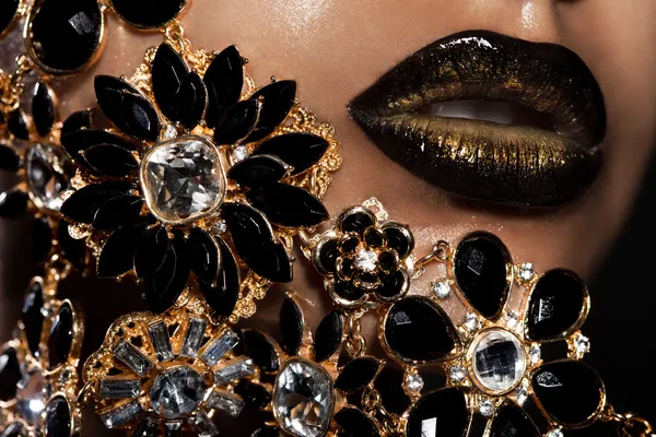 Labios femeninos con joyas doradas —  Fotos de Stock