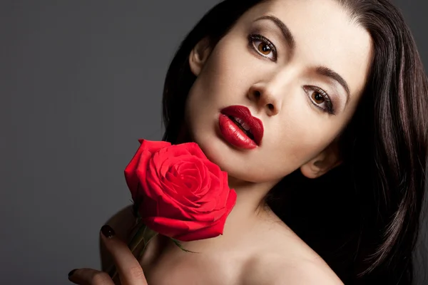Piękna kobieta z czerwoną różą — Zdjęcie stockowe