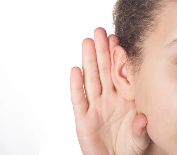 Menina ouvindo com a mão em uma orelha — Fotografia de Stock