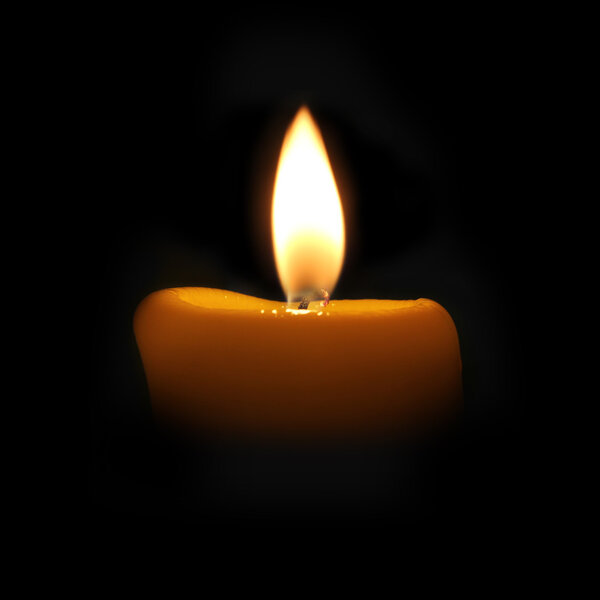 yellow candle in a dark room