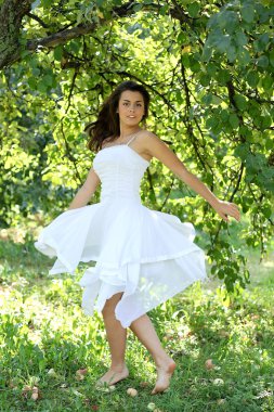 güzel bir genç kadın sabah aydınlık yaz meyve bahçesinde dans