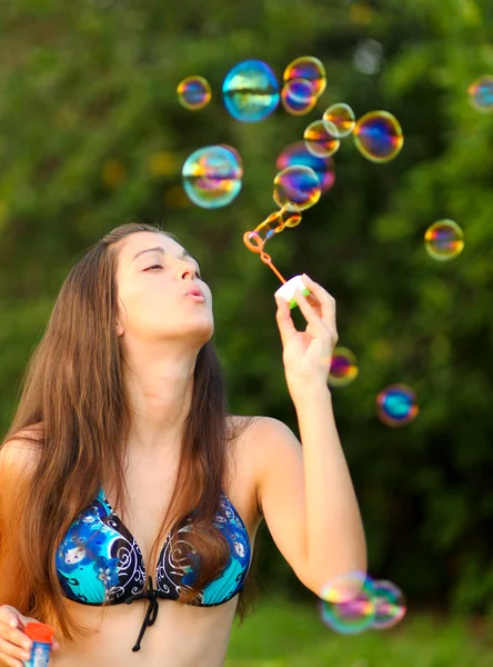 Pretty woman inflating soap-bubbles — Stock Photo, Image