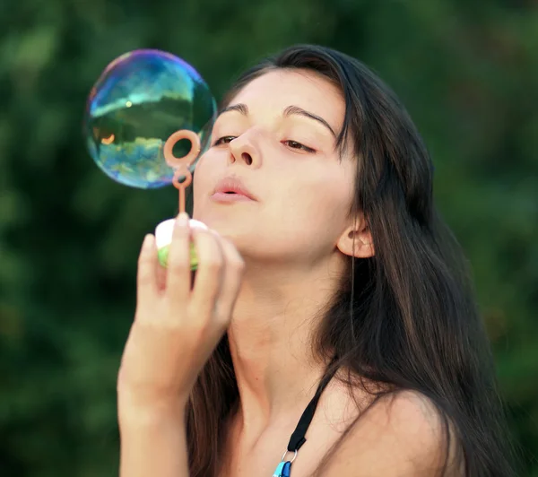 Mulher bonita inflando bolhas de sabão — Fotografia de Stock