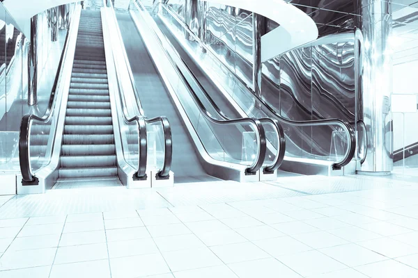 Contemporary moving escalator stairs inside business blue hall — Stock Photo, Image