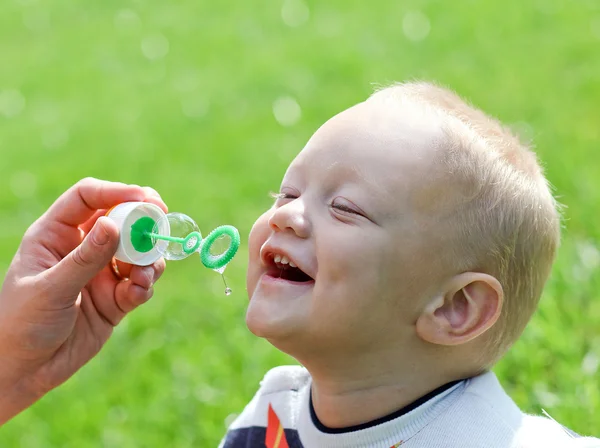 Happy child inflating soap bubbles — Stock Photo, Image