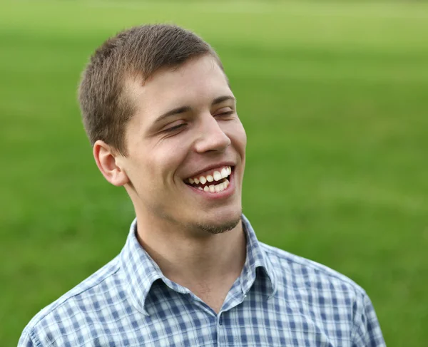 Beau jeune homme souriant jouissant dans la nature — Photo