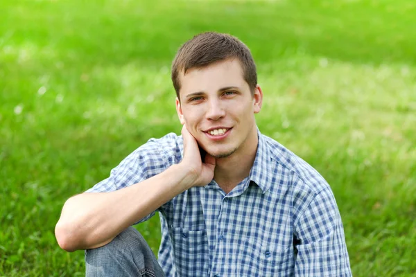 Krásný usměvavý mladý muž těší v přírodě — Stock fotografie