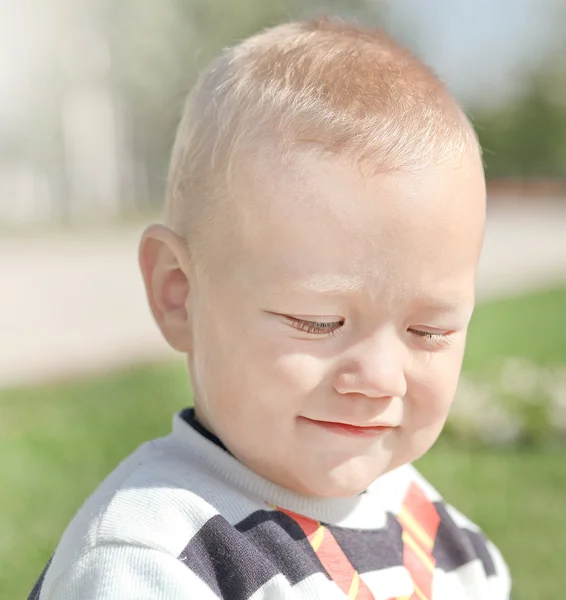 Rozkošně chlapec zářivě zelené trávě v pa — Stock fotografie