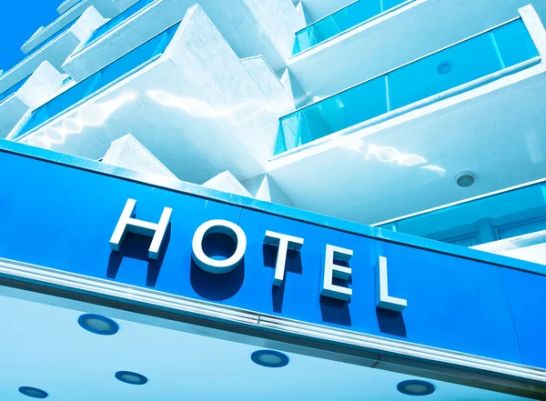 Hotel sign over light blue modern facade — Stock Photo, Image