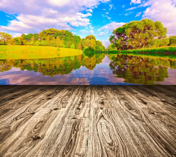 Lichte pittoreske scène van prachtig platteland meer in zonnige zomer park over blauwe hemel met eerste dageraad stralen op de muur binnen kamer interieur met frame getextureerde houten bruin paneel vloer achtergrond — Stockfoto