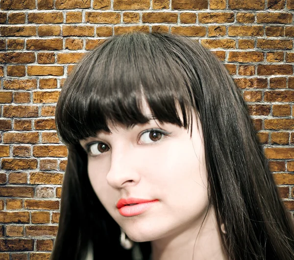 Woman looking over grungy brick — Stock Photo, Image