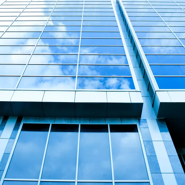 Hermosas nubes que reflejan en la pared de cristal de rascacielos — Foto de Stock