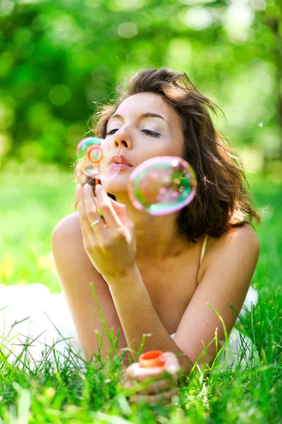 Menina inflando bolhas de sabão coloridas — Fotografia de Stock