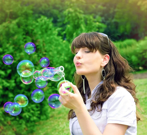 Giovane ragazza gonfiando bolle di sapone — Foto Stock