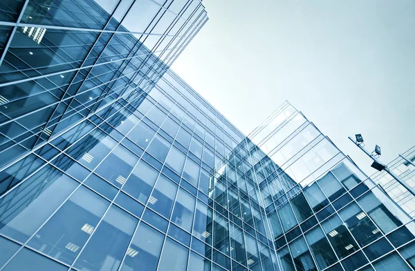 De groothoek van vooruitzichten met het oog op stalen blauwe achtergrond van glas hoog stijgingsgebouw wolkenkrabbers — Stockfoto