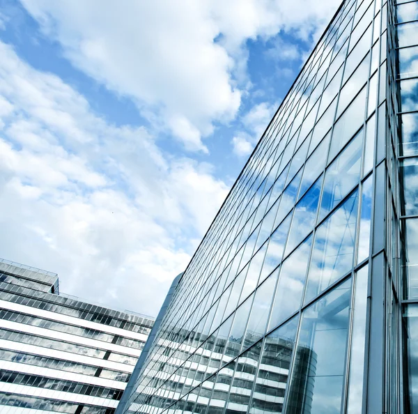 Näkökulma laajakulma lasi korkean rakennuksen pilvenpiirtäjiä teräksen sininen tausta — kuvapankkivalokuva