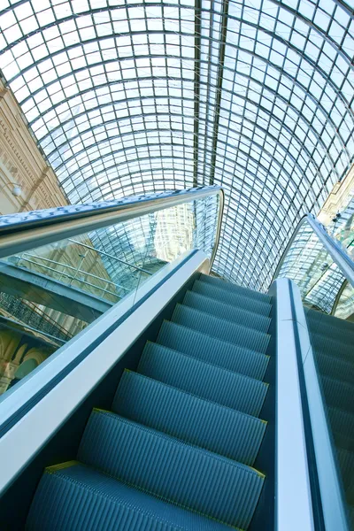 Wide angled view to perspective escalators stairway inside contemporary blue glass business centre, concept of successful career elevation — Stock Photo, Image