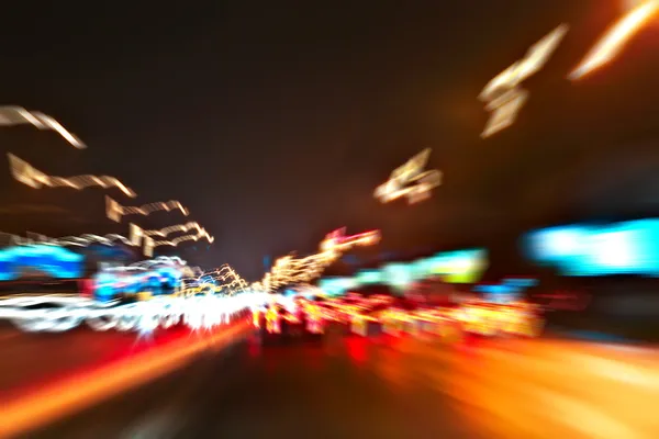 Perspective and panoramic wide angle view of modern light blue illuminated and spacious high-speed urban road and moving cars with fast blurred trail of headlights in vanishing traffic motion at night — Stock Photo, Image