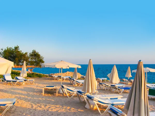 Beautiful sunny lounges near the pool over blue bright evening sky in Greece — Stock Photo, Image