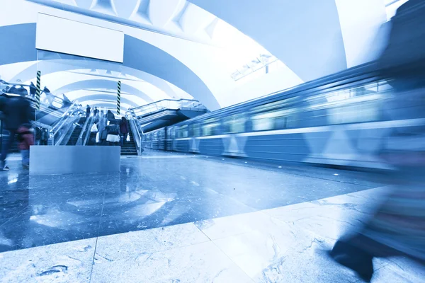 Perspectiva amplia vista angular de la moderna luz azul iluminada y amplia estación de metro público de mármol con rápido rastro borroso de tren en movimiento de tráfico en fuga — Foto de Stock