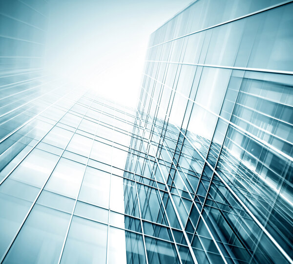 Panoramic and prospective wide angle view to steel light blue background of glass high rise building skyscraper commercial modern city of future. Business concept of successful industrial architecture