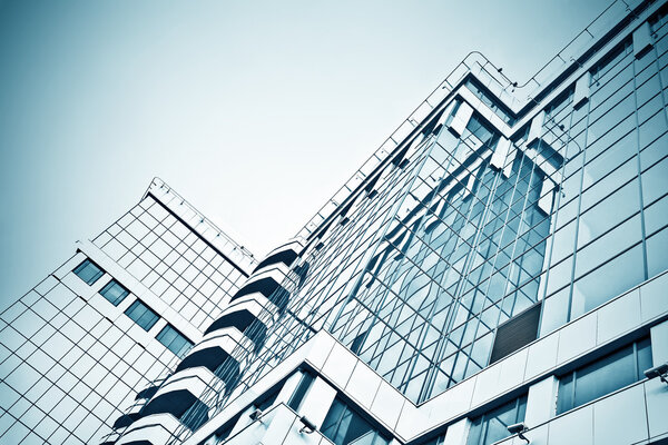 Panoramic and prospective wide angle view to steel light blue background of glass high rise building skyscraper commercial modern city of future. Business concept of successful industrial architecture