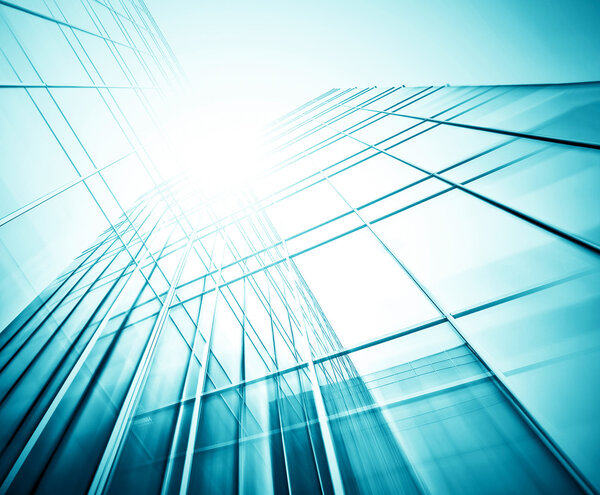 Panoramic and prospective wide angle view to steel light blue background of glass high rise building skyscraper commercial modern city of future. Business concept of successful industrial architecture