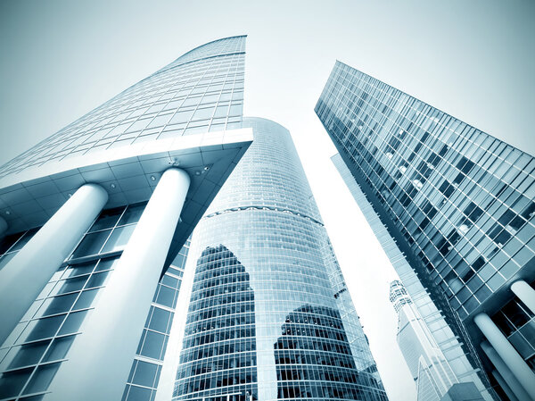 Panoramic and prospective wide angle view to steel light blue background of glass high rise building skyscraper commercial modern city of future. Business concept of successful industrial architecture