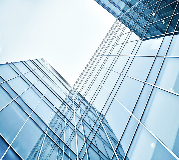 Panoramic and prospective wide angle view to steel light blue background of glass high rise building skyscraper commercial modern city of future. Business concept of successful industrial architecture