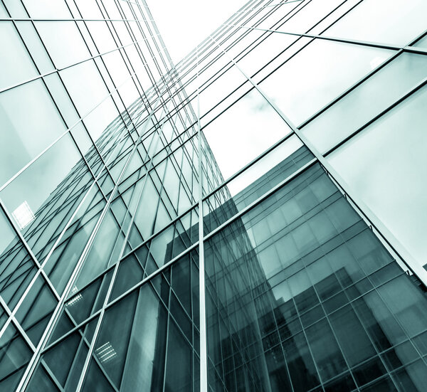 Panoramic and prospective wide angle view to steel light blue background of glass high rise building skyscraper commercial modern city of future. Business concept of successful industrial architecture