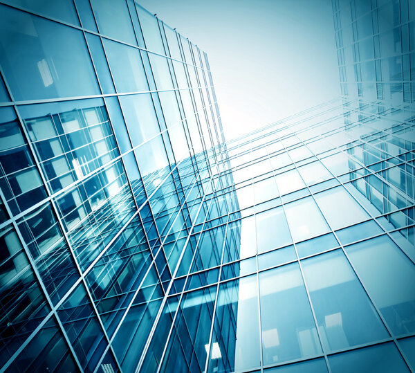 Panoramic and prospective wide angle view to steel light blue background of glass high rise building skyscraper commercial modern city of future. Business concept of successful industrial architecture