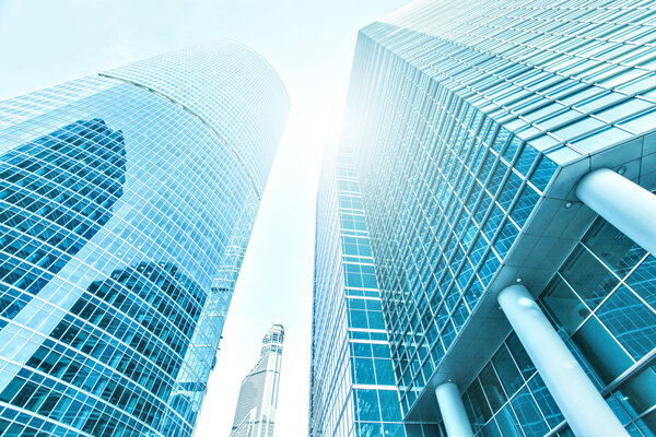 Panoramic and prospective wide angle view to steel light blue background of glass high rise building skyscraper commercial modern city of future. Business concept of successful industrial architecture