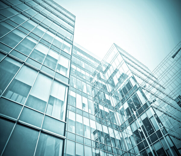 Panoramic and prospective wide angle view to steel light blue background of glass high rise building skyscraper commercial modern city of future. Business concept of successful industrial architecture