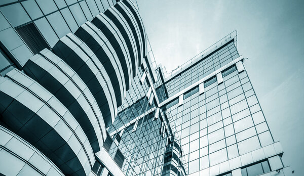 Panoramic and prospective wide angle view to steel light blue background of glass high rise building skyscraper commercial modern city of future. Business concept of successful industrial architecture