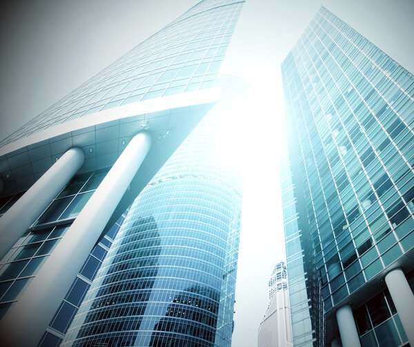 Panoramic and prospective wide angle view to steel light blue background of glass high rise building skyscraper commercial modern city of future. Business concept of successful industrial architecture