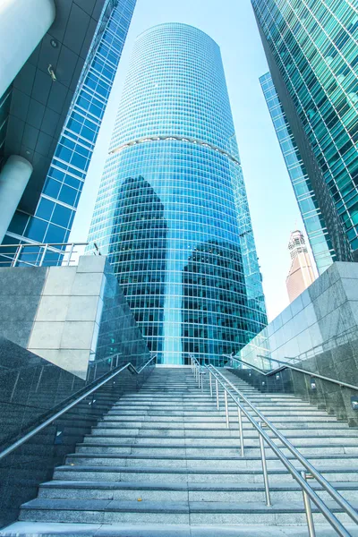 Panoramic and prospective wide angle view to steel light blue background of glass high rise building skyscraper commercial modern city of future. Business concept of successful industrial architecture — Stock Photo, Image