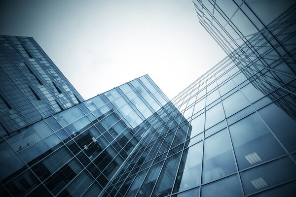 Panoramic and prospective wide angle view to steel light blue background of glass high rise building skyscraper commercial modern city of future. Business concept of successful industrial architecture