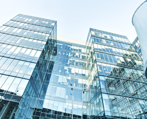 Panoramic and prospective wide angle view to steel light blue background of glass high rise building skyscraper commercial modern city of future. Business concept of successful industrial architecture