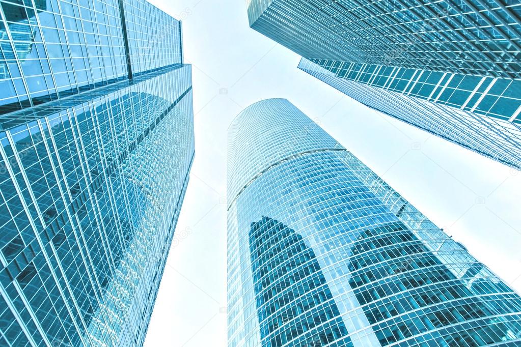 Panoramic and prospective wide angle view to steel light blue background of glass high rise building skyscraper commercial modern city of future. Business concept of successful industrial architecture